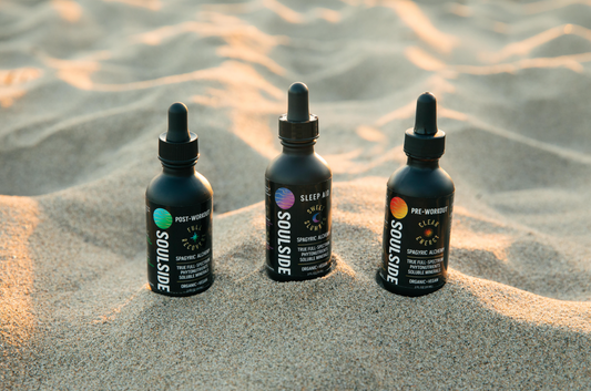 Image of Soulside tinctures in sand - three natural herbal supplement tinctures for natural energy, recovery, sleep, immunity, brain health.