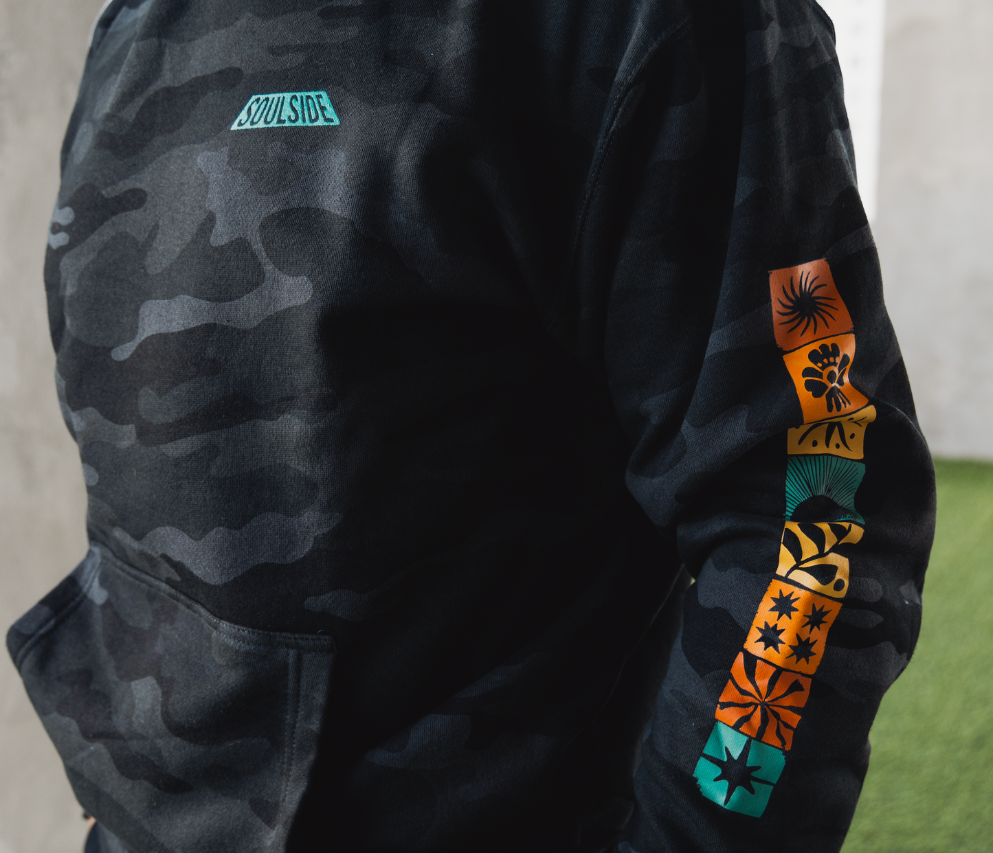 Image of athletic high performance man wearing Soulside industry cozy hoodie, a super cozy, heavyweight black camo hoodie with original artist design.
