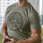 Image of athletic, high performance man with muscles wearing Soulside Begin Again t-shirt in a gym. The t-shirt depicts a design by an artist with hand-drawn sun and ocean elements.