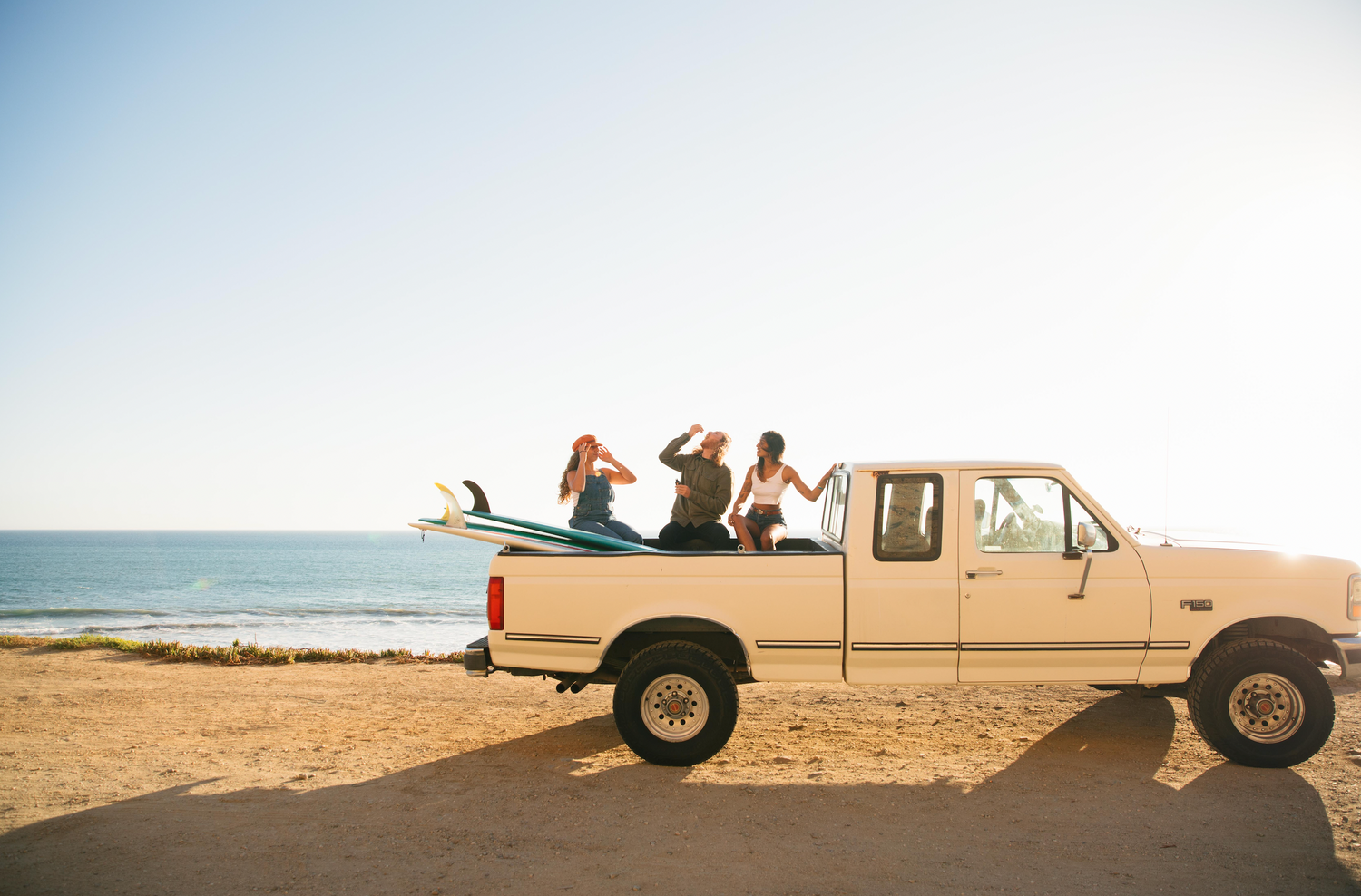 Image of surfers at the beach in the back of a truck taking Soulside energy tincture before a surf session