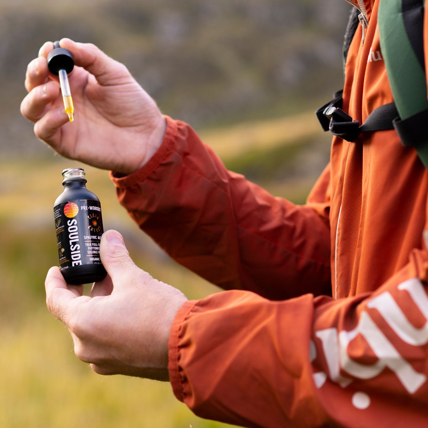 Image of hiker's hands holding Soulside Clean Energy natural herbal supplement for natural energy, focus, endurance, athletic performance and stamina.